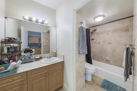 a bathroom with a double vanity sink toilet mirror and shower