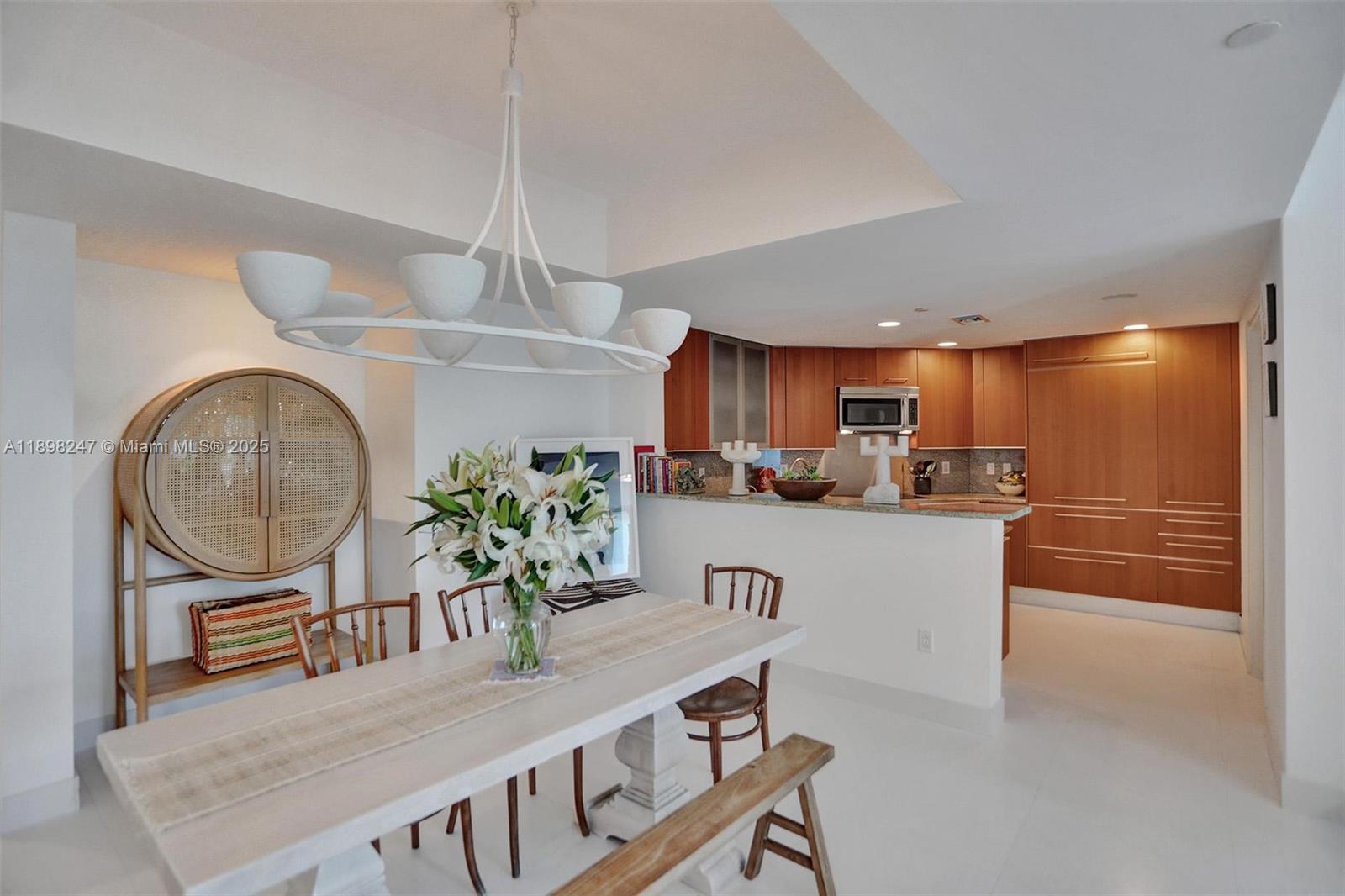 2627 South Bayshore Drive, Unit 506 Coconut Grove, FL 33133 - Photo 18 of 61 a kitchen with stainless steel appliances granite countertop a table chairs in it and wooden floors