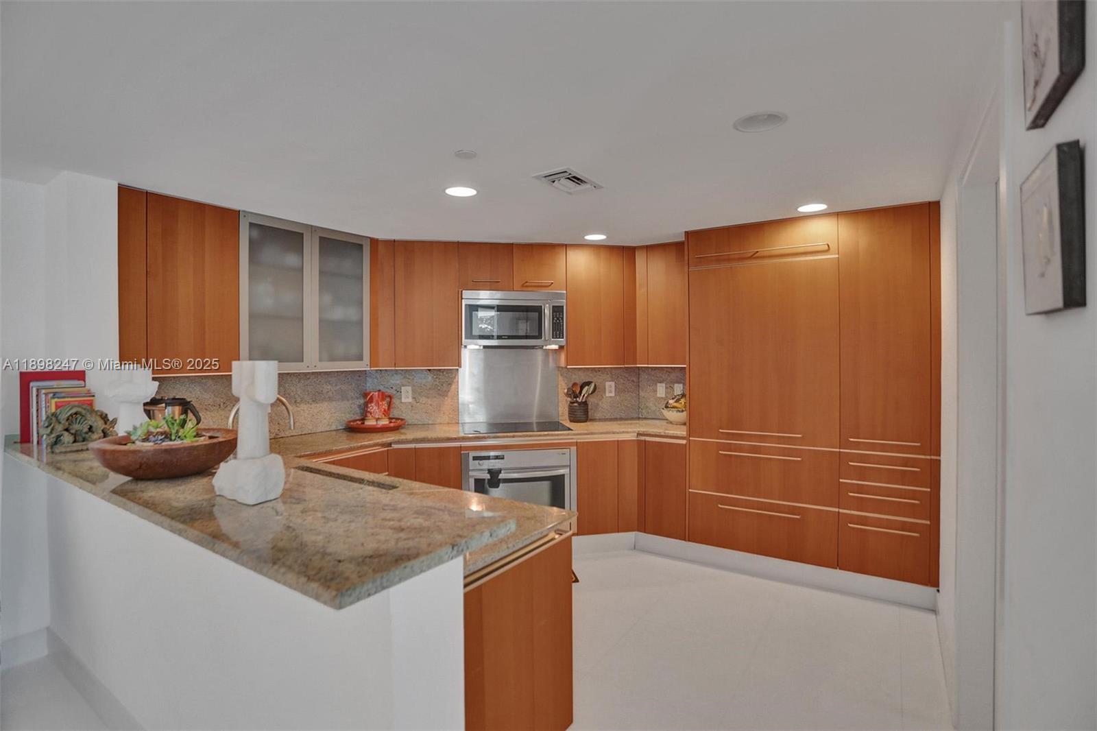 2627 South Bayshore Drive, Unit 506 Coconut Grove, FL 33133 - Photo 19 of 61 a kitchen with stainless steel appliances granite countertop a sink and cabinets