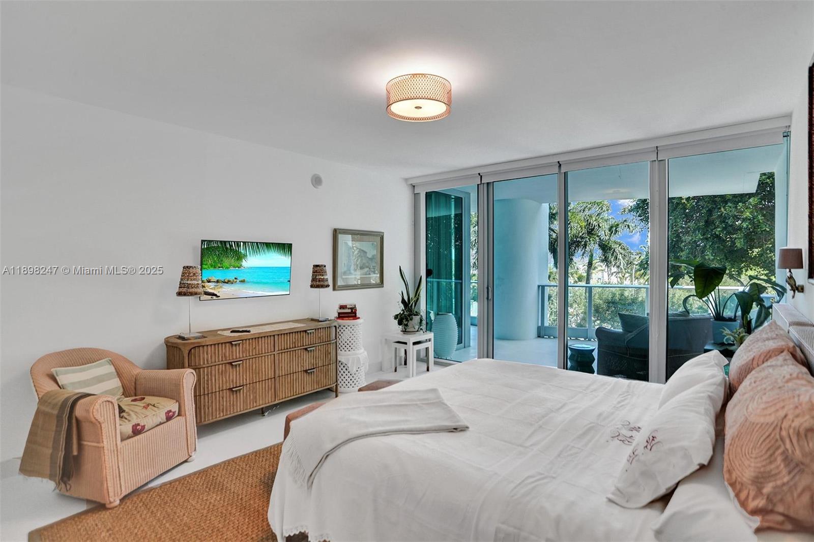 2627 South Bayshore Drive, Unit 506 Coconut Grove, FL 33133 - Photo 23 of 61 a bedroom with furniture a flat screen tv and a large window