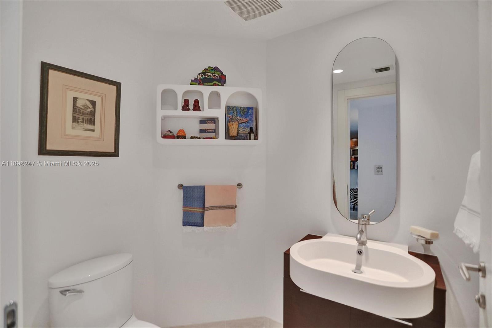 2627 South Bayshore Drive, Unit 506 Coconut Grove, FL 33133 - Photo 9 of 61 a bathroom with a toilet sink and mirror