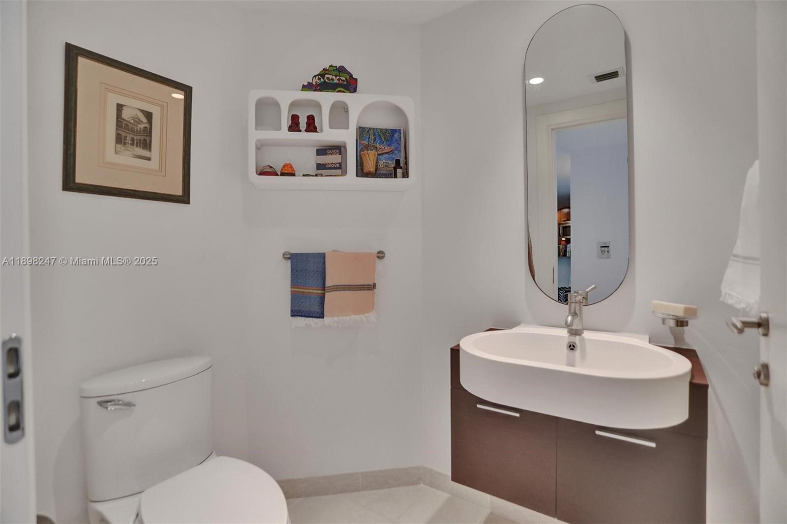 2627 South Bayshore Drive, Unit 506 Coconut Grove, FL 33133 - Photo 10 of 61 a bathroom with a toilet sink and mirror