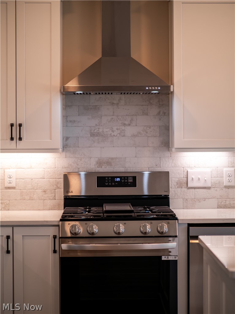 34270 Brookside Lane North Ridgeville, OH 44039 - Photo 19 of 50 Kitchen with stainless steel appliances, white cabinetry, light stone counters, and tasteful backsplash