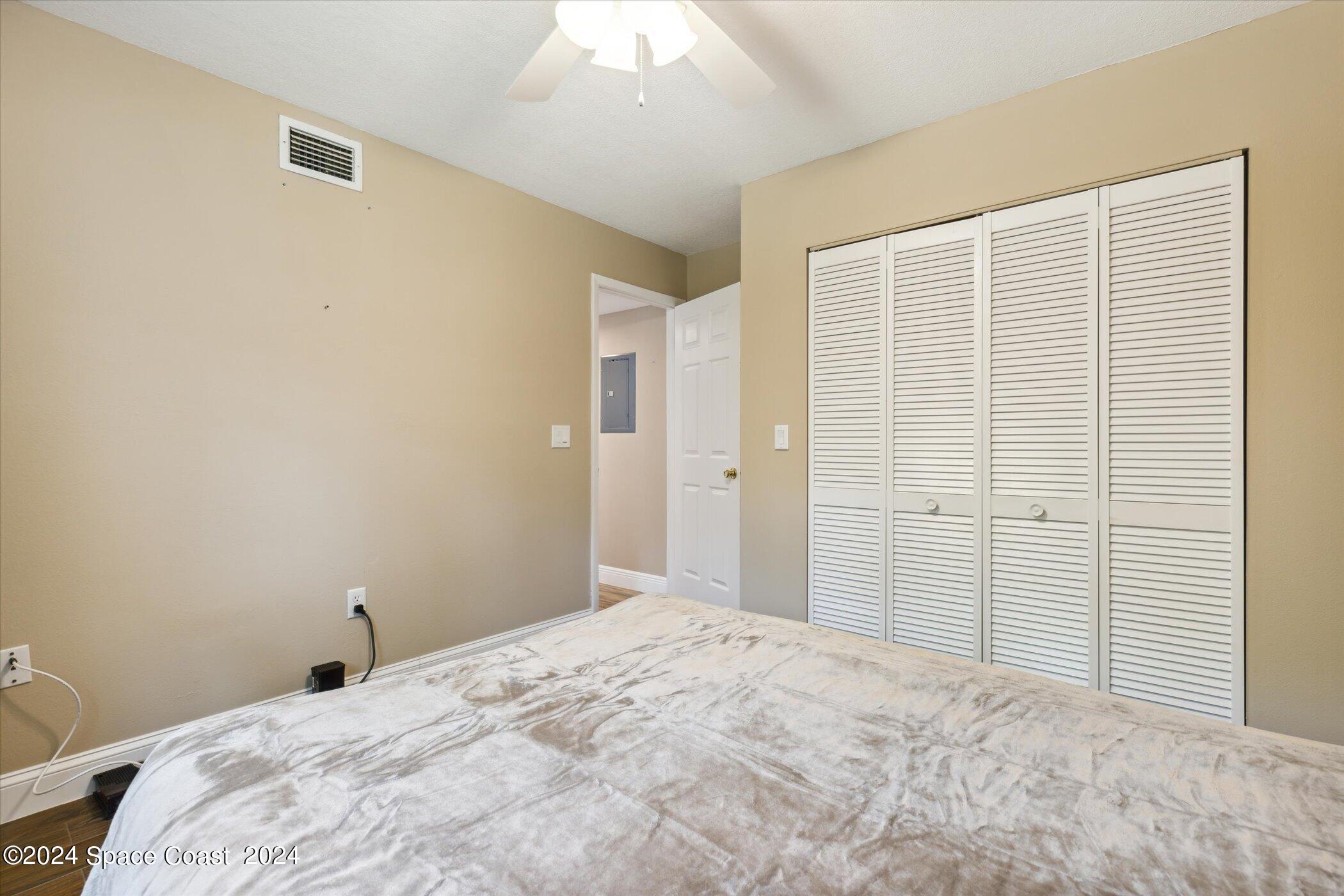712 Ridge Club Drive Melbourne, FL 32934 - Photo 26 of 32 a bedroom with a large bed and a chandelier