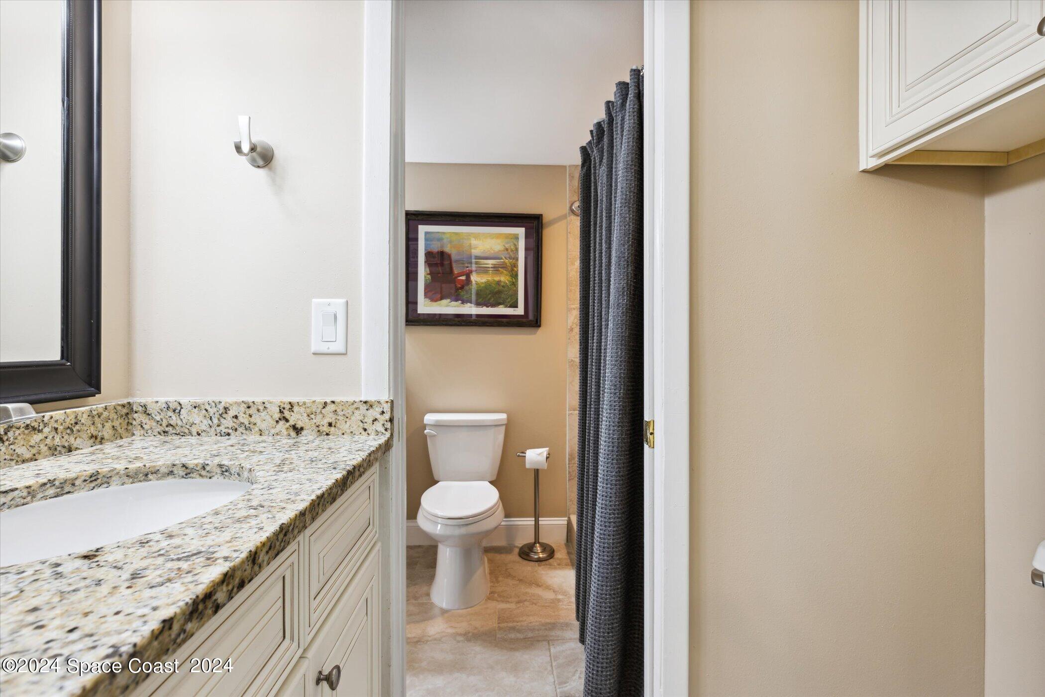712 Ridge Club Drive Melbourne, FL 32934 - Photo 8 of 32 a bathroom with a granite countertop sink a toilet and a mirror