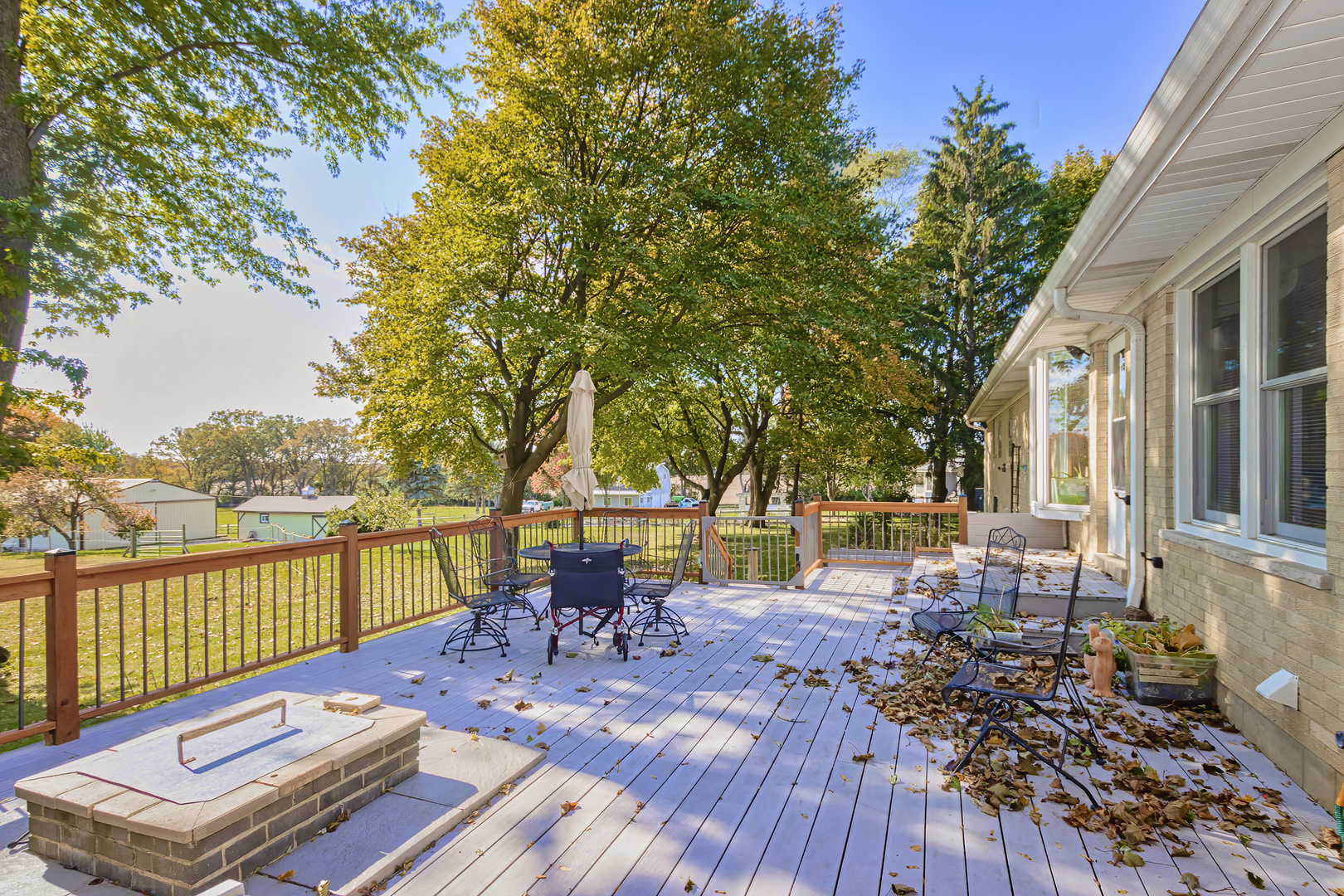 3511 West Gracy Road McHenry, IL 60050 - Photo 32 of 49 a view of a roof deck with table and chairs a barbeque with wooden floor and fence