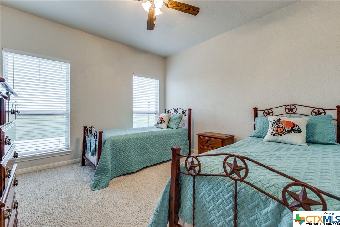 8177 Boenig Road Seguin, TX 78155 - Photo 13 of 21 a bedroom with two beds and a chandelier