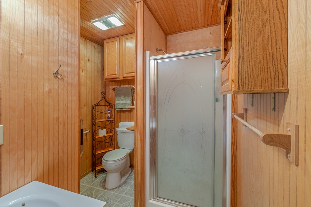932 Shin Oak Road Menard, TX 76859 - Photo 14 of 23 a bathroom with a granite countertop toilet a sink and shower