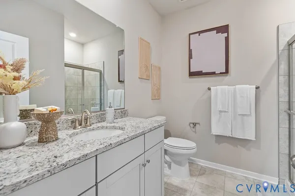 a bathroom with a granite countertop sink a toilet and a mirror
