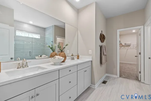 a bathroom with a double vanity sink mirror and shower