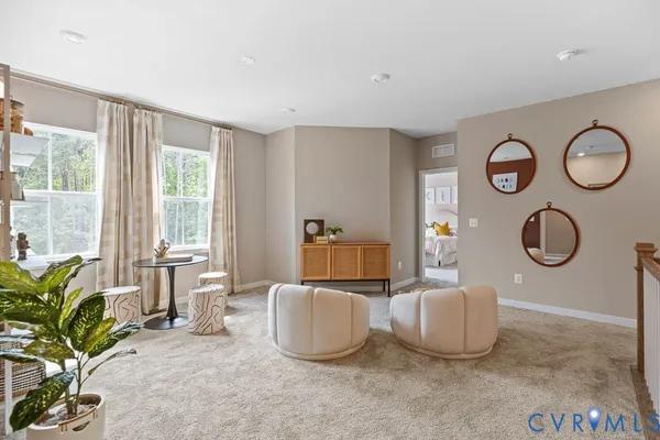 a living room with furniture a window and a potted plant