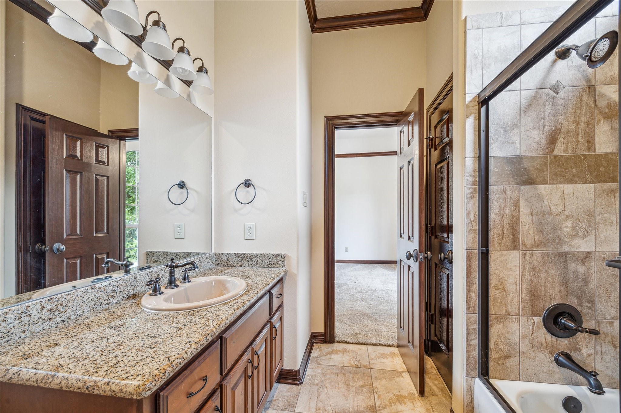 12602 Overcup Drive Houston, TX 77024 - Photo 27 of 36 a bathroom with a granite countertop sink a mirror and shower