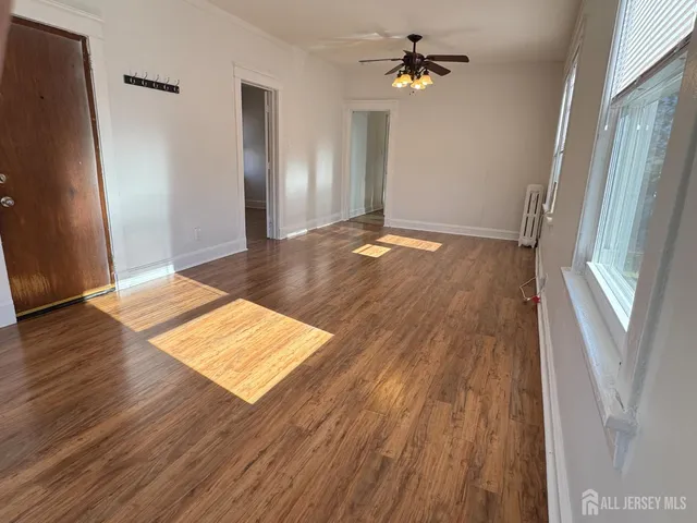 an empty room with wooden floor and staircase