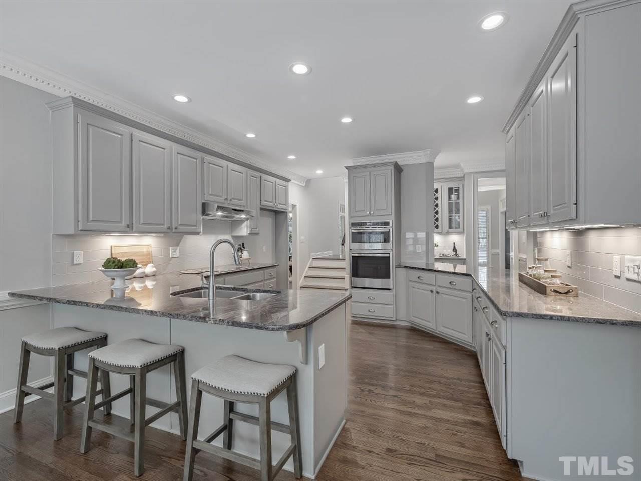 104 Beech Slope Way Cary, NC 27518 - Photo 11 of 30 a kitchen with kitchen island granite countertop wooden cabinets and stainless steel appliances