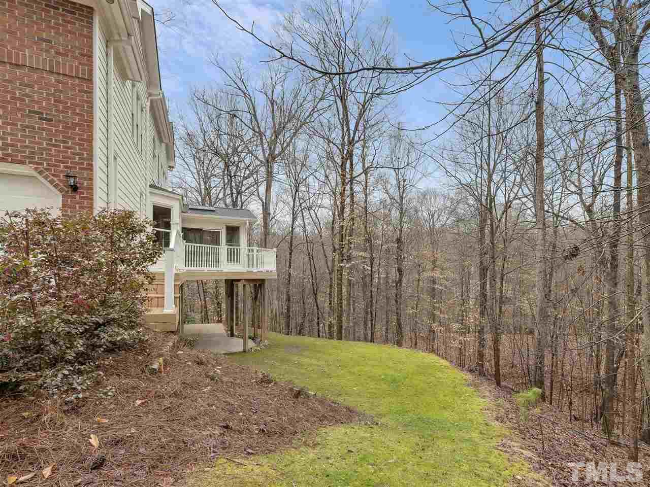 104 Beech Slope Way Cary, NC 27518 - Photo 27 of 30 a backyard of a house with large trees and wooden fence