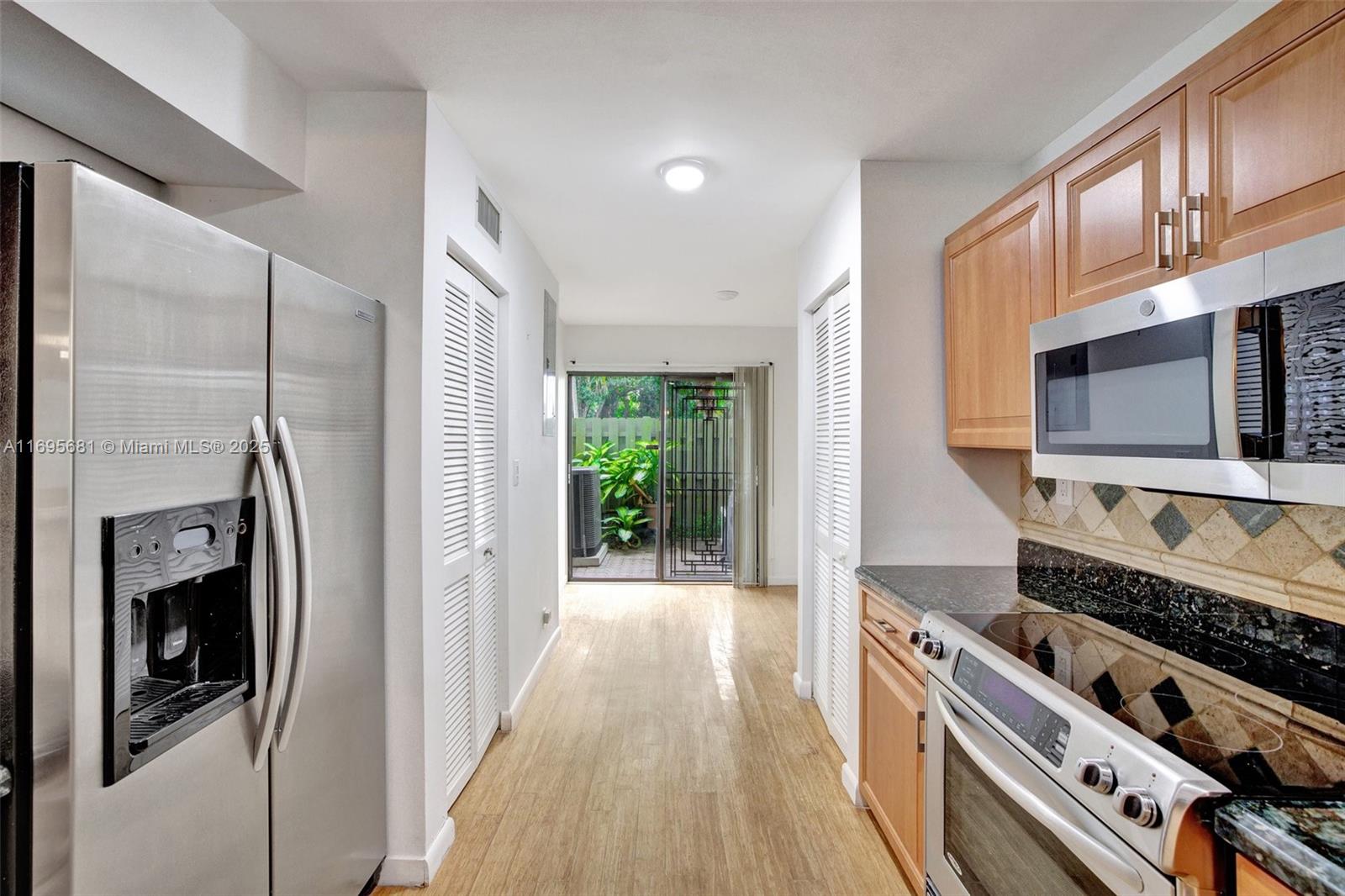 93 Northeast 17th Court, Unit 93 Fort Lauderdale, FL 33305 - Photo 5 of 43 a kitchen with stainless steel appliances granite countertop a stove a sink and a refrigerator