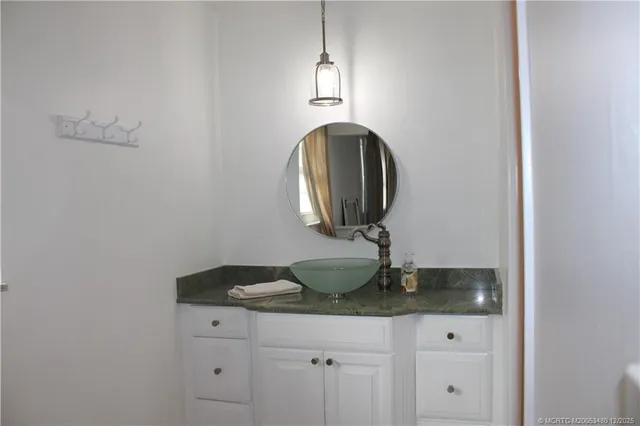 a bathroom with a granite countertop sink and mirror