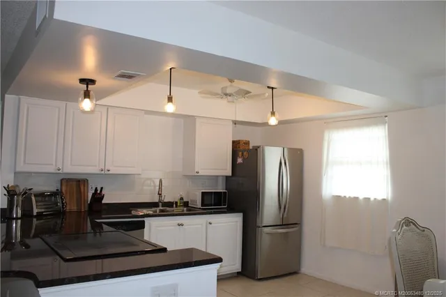 a kitchen with stainless steel appliances granite countertop a refrigerator a sink dishwasher a stove and a refrigerator