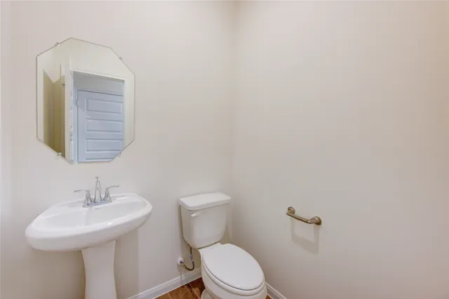 a bathroom with a sink a toilet and mirror