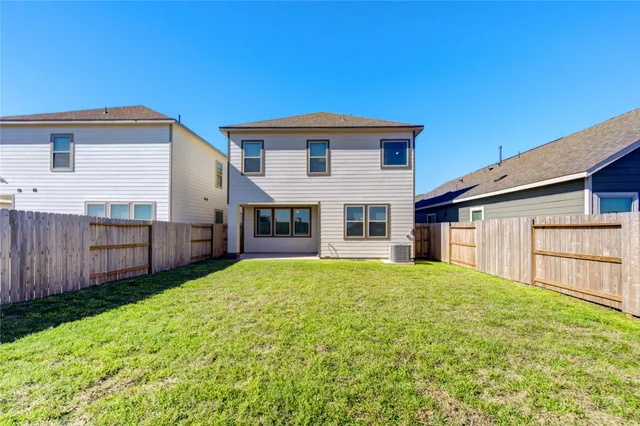 a view of house with backyard and tub