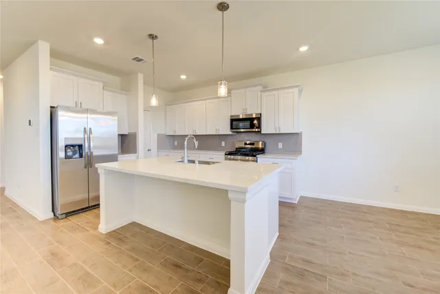 a kitchen with stainless steel appliances a refrigerator sink and microwave
