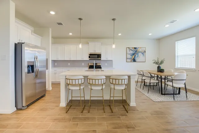 a large kitchen with a table and chairs in it