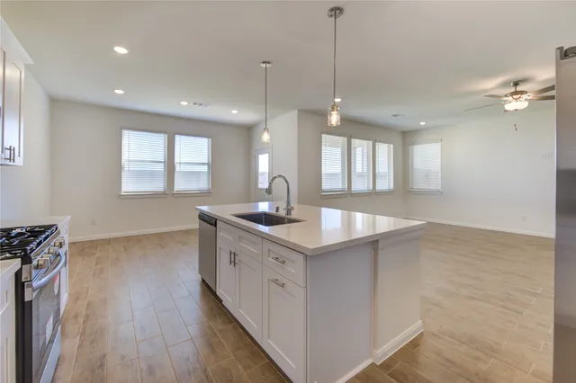 a kitchen with granite countertop a sink a counter space appliances and a window