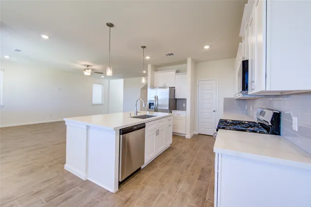 a large kitchen with stainless steel appliances granite countertop a stove and a sink