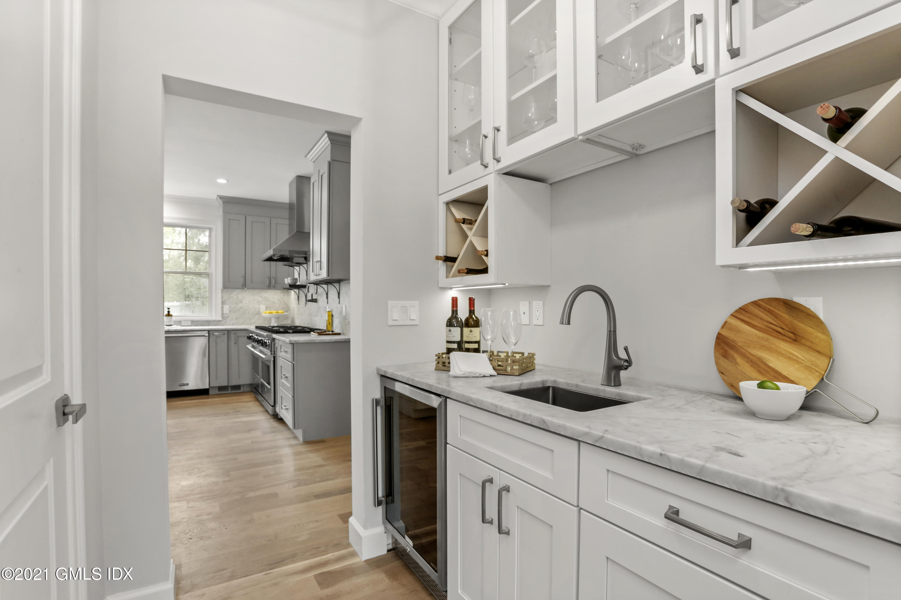 12 Cottontail Road Cos Cob, CT 06807 - Photo 7 of 35 a kitchen with stainless steel appliances granite countertop a sink a stove and white cabinets with wooden floor