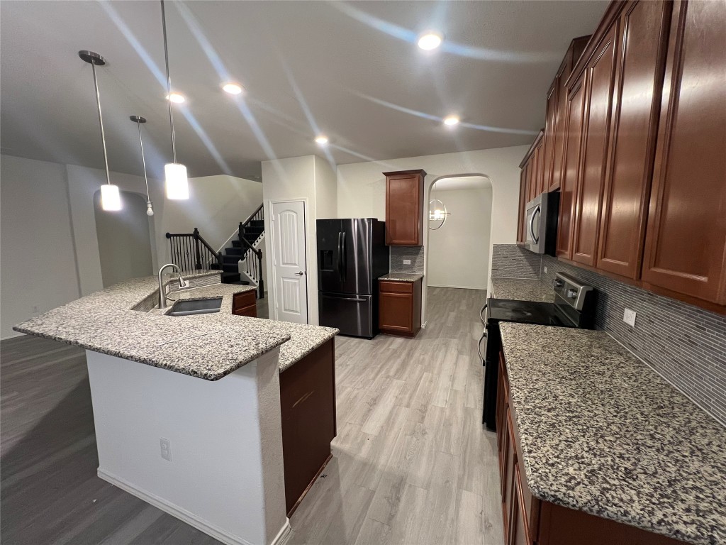 112 West Point Way Elgin, TX 78621 - Photo 2 of 9 a kitchen with stainless steel appliances granite countertop granite counter tops and wooden floors