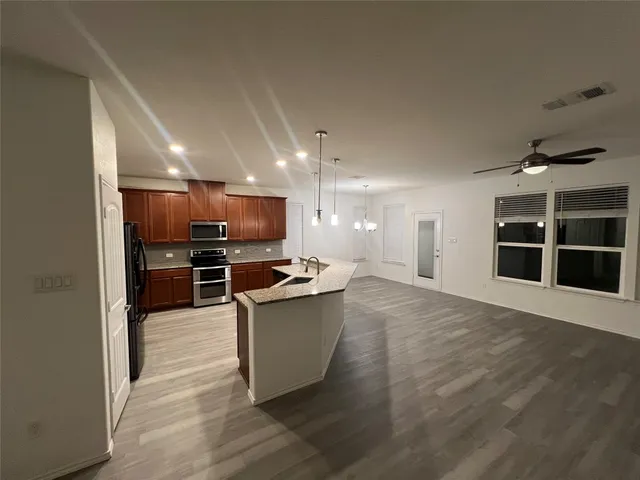 an empty room with wooden floor and a hallway