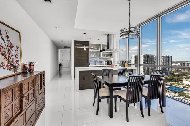 a view of a dining room and livingroom with furniture wooden floor a chandelier