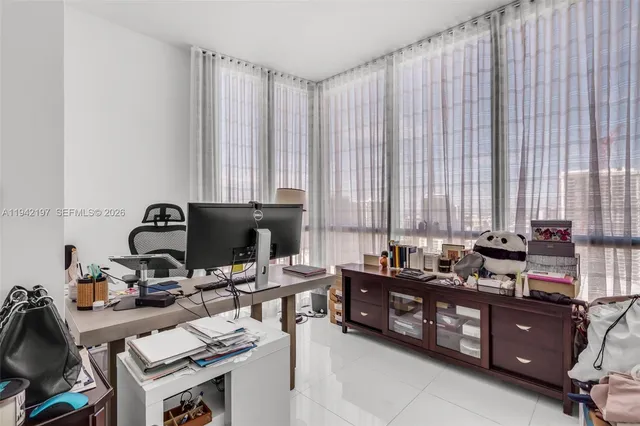 a view of a workspace with furniture and a window