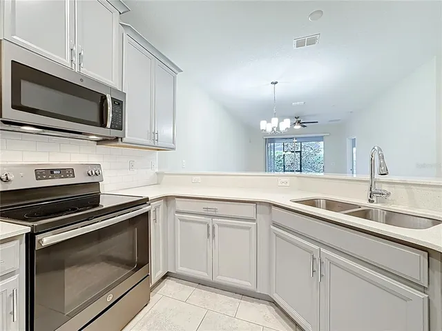a kitchen with white cabinets stainless steel appliances and sink