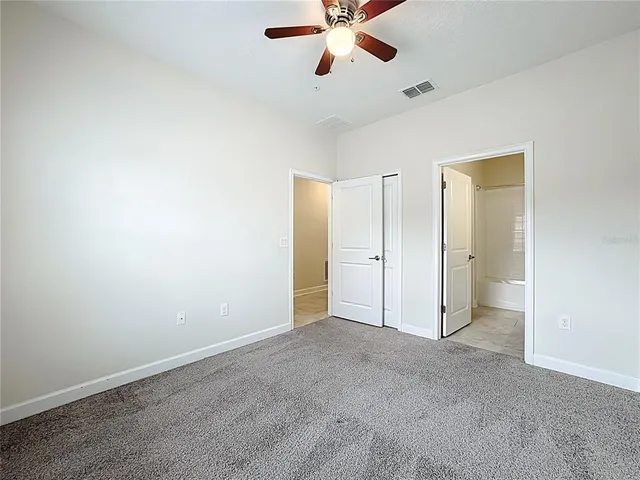 an empty room with closet and windows