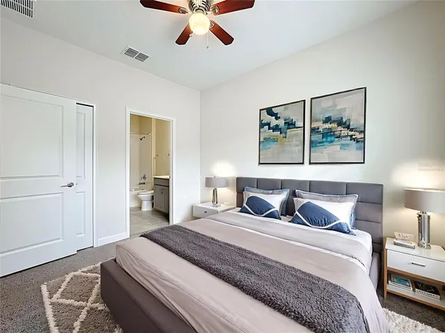a bedroom with a large bed and a chandelier