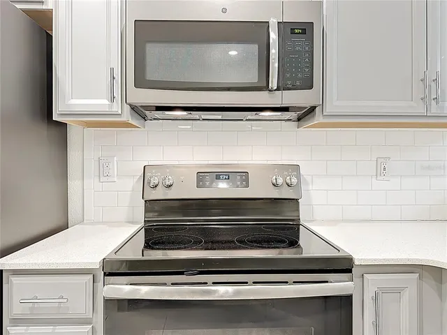 a stove top oven sitting inside of a kitchen