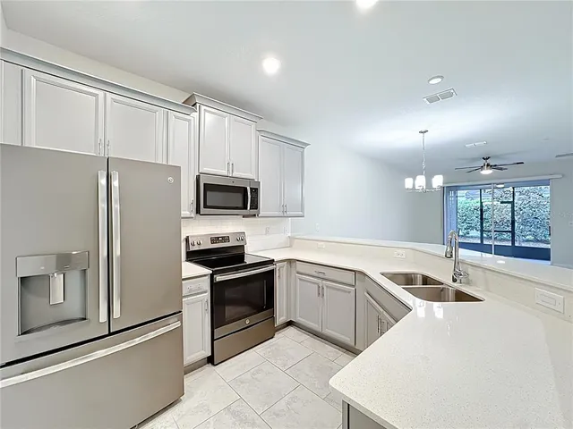 a kitchen with granite countertop a sink stainless steel appliances and cabinets
