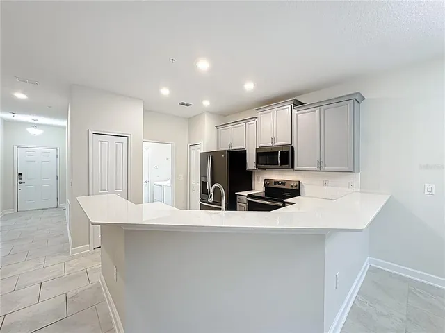 a kitchen with stainless steel appliances a refrigerator sink and microwave