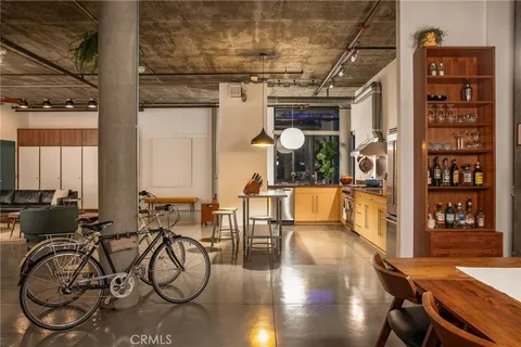 a kitchen with stainless steel appliances kitchen island granite countertop a table and chairs in it