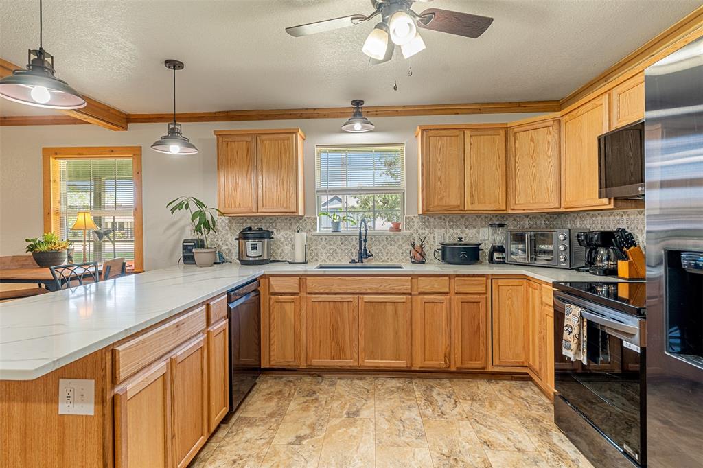 113 L B J Ranch Road Trinidad, TX 75163 - Photo 5 of 11 Kitchen with a peninsula, black range with electric cooktop, healthy amount of natural light, backsplash, and ornamental molding