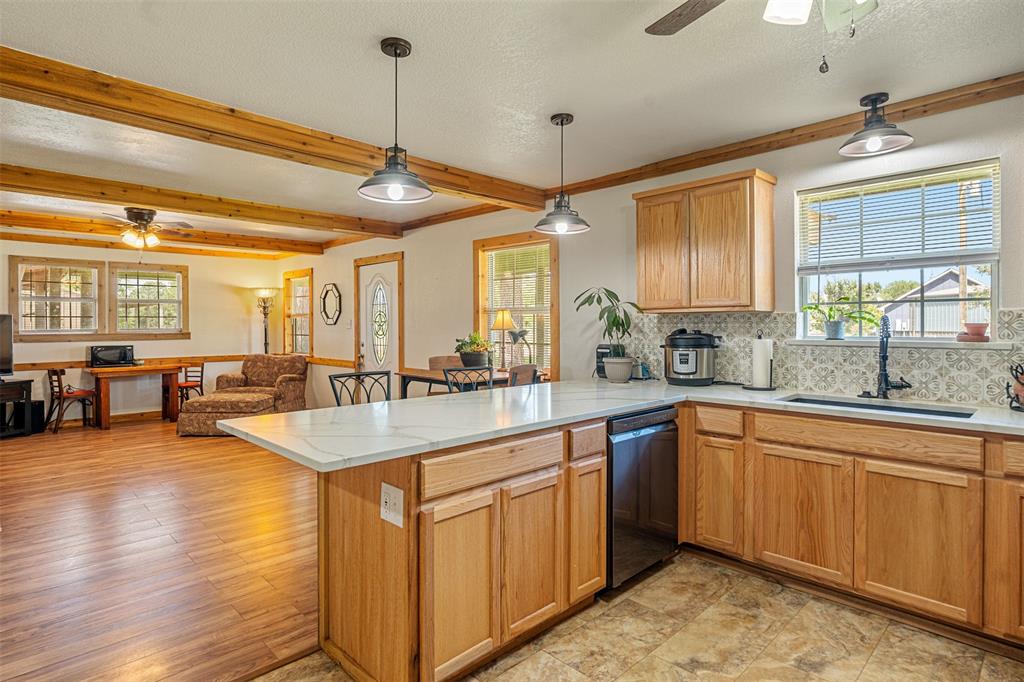 113 L B J Ranch Road Trinidad, TX 75163 - Photo 6 of 11 Kitchen with ceiling fan, a peninsula, dishwashing machine, plenty of natural light, and beamed ceiling