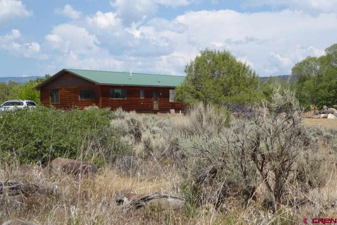 19850 2325th Road Cedaredge, CO 81413 - Photo 2 of 35 a front view of a house with yard and trees