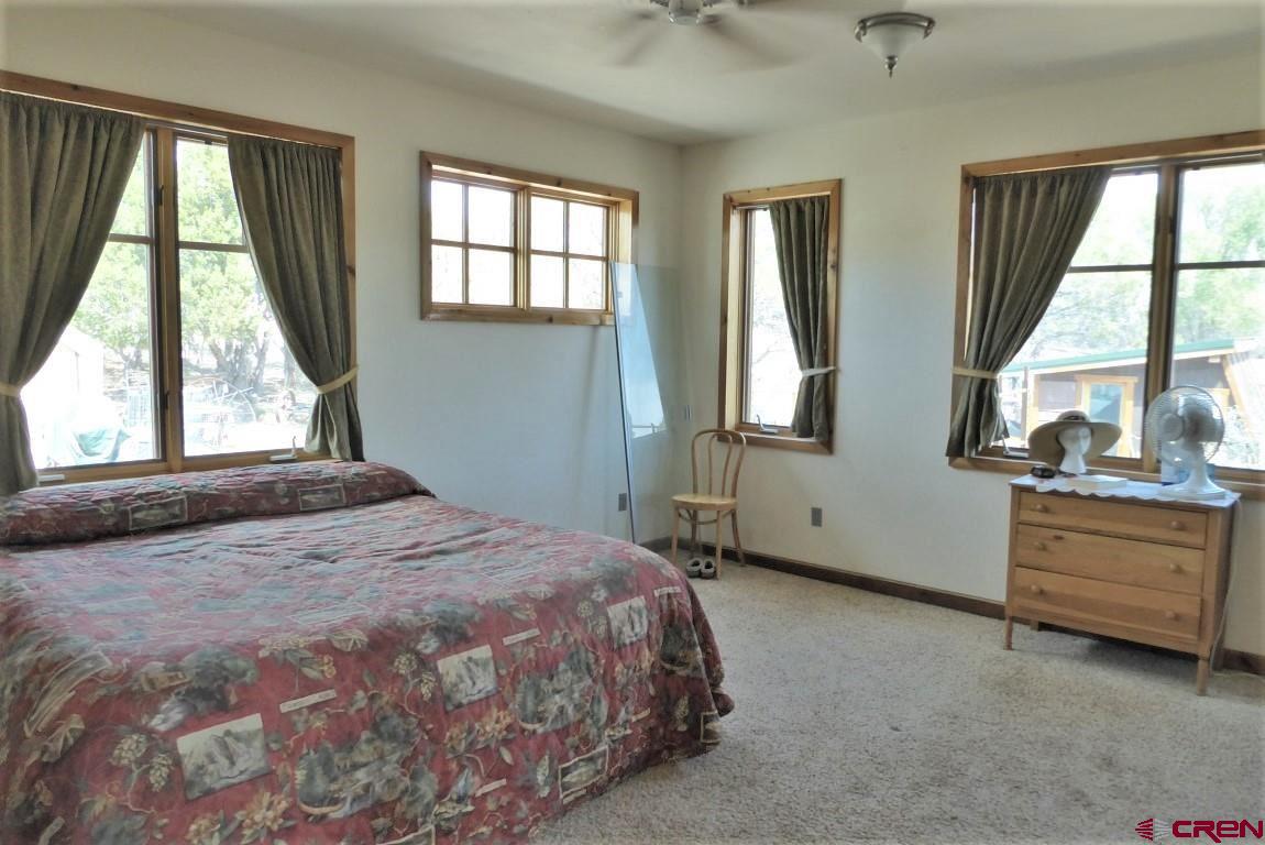 19850 2325th Road Cedaredge, CO 81413 - Photo 16 of 35 a bedroom with a bed and a large window