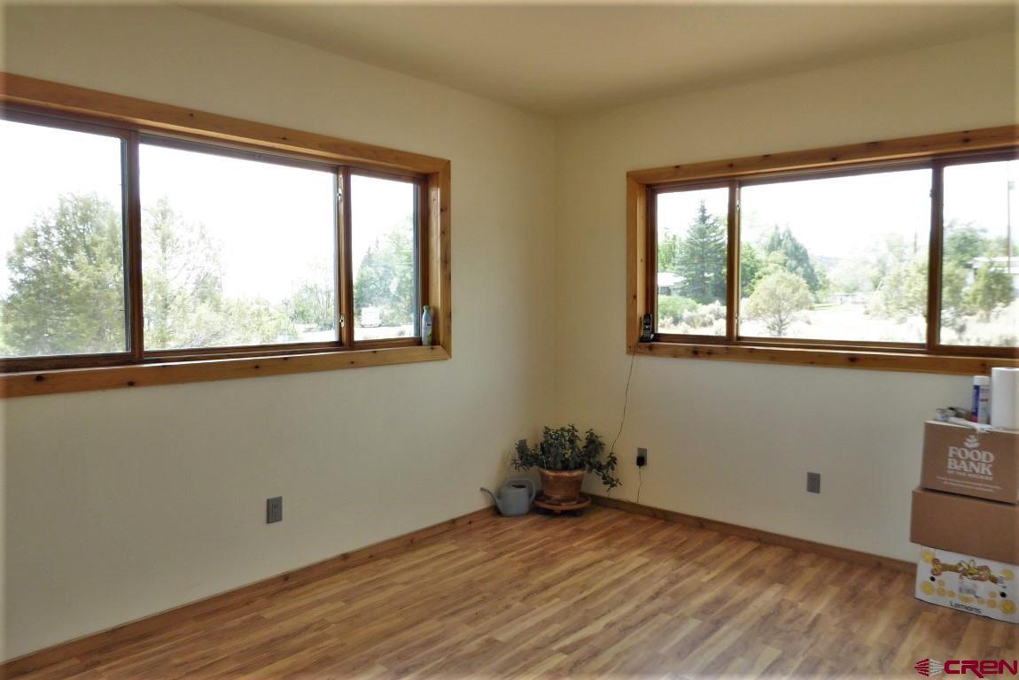 19850 2325th Road Cedaredge, CO 81413 - Photo 21 of 35 a view of an empty room with wooden floor and a window