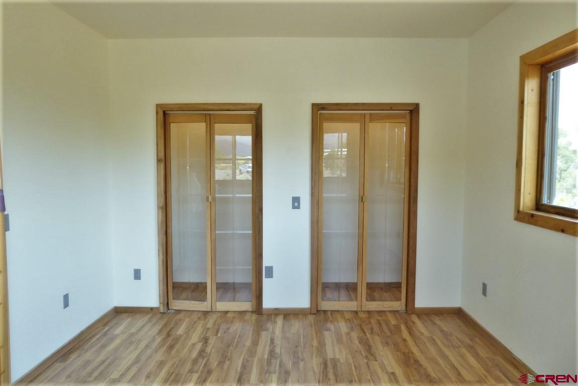 19850 2325th Road Cedaredge, CO 81413 - Photo 22 of 35 an empty room with wooden floor and windows