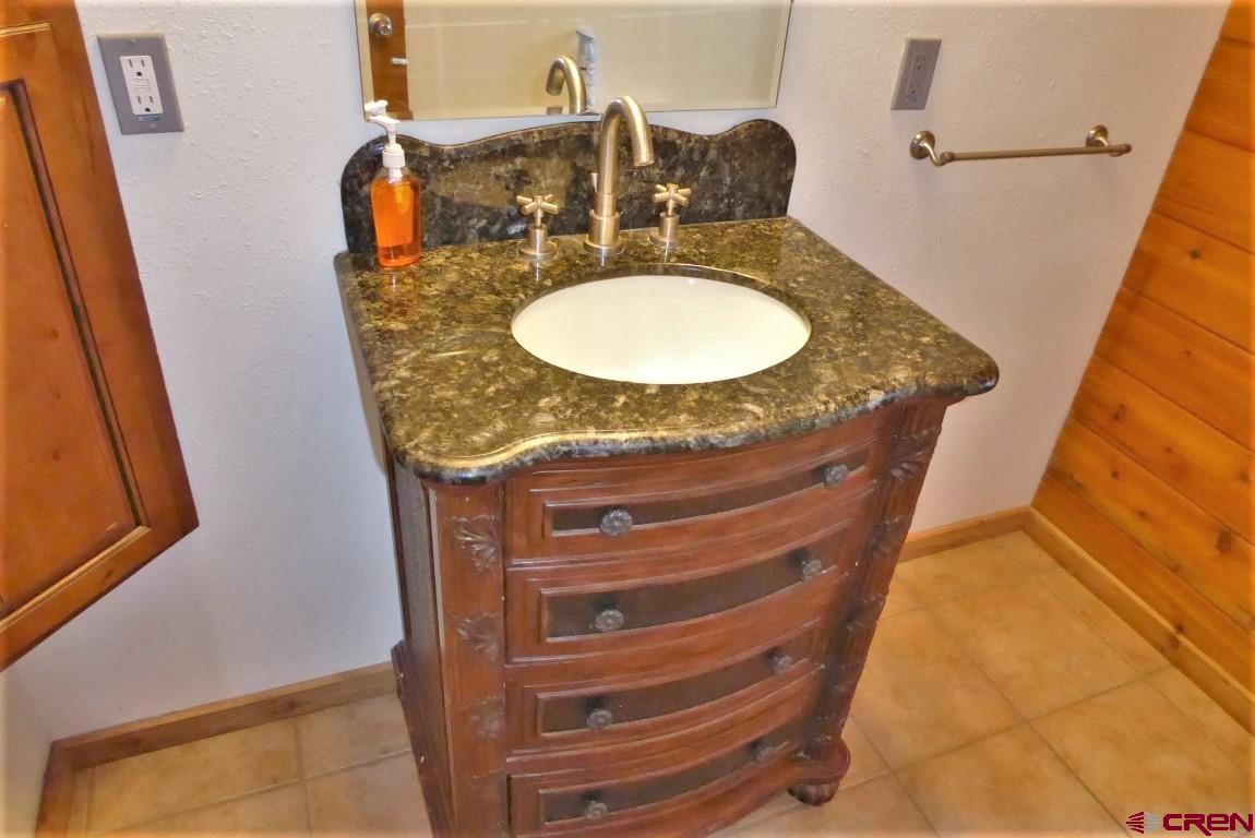 19850 2325th Road Cedaredge, CO 81413 - Photo 24 of 35 a bathroom with a granite countertop sink and a mirror