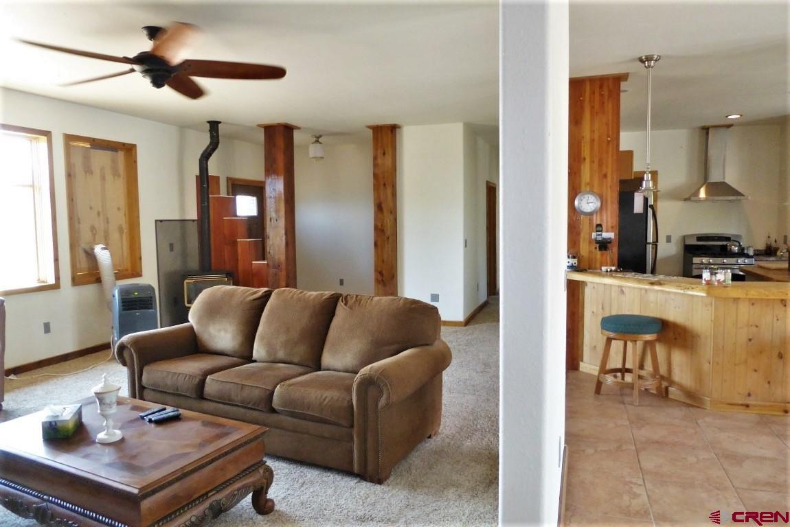 19850 2325th Road Cedaredge, CO 81413 - Photo 9 of 35 a living room with furniture a ceiling fan and a window