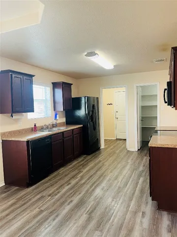 a kitchen with stainless steel appliances kitchen island granite countertop a stove refrigerator and cabinets