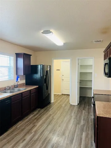 a kitchen with granite countertop a refrigerator and a sink